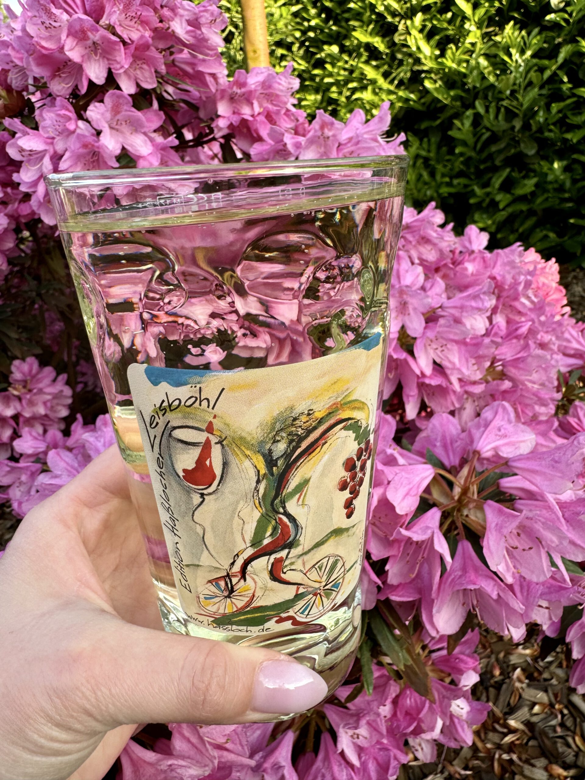 Hand hält Dubbeglas mit Leisböhler Logo in der Hand